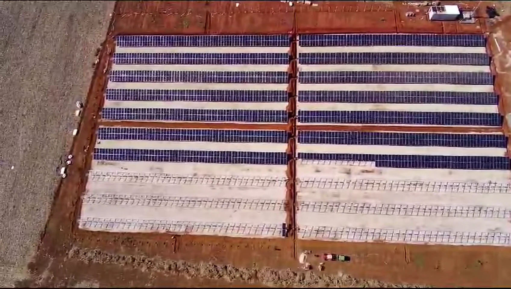 Vista aérea de usina solar de grande porte com longas fileiras de módulos